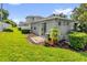 Private backyard with well-maintained lawn, patio, lush landscaping, and sliding glass door access at 1122 Sandstone Run, Sanford, FL 32771