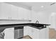 Contemporary kitchen showcasing white cabinets, stainless steel dishwasher, and black countertops at 1122 Sandstone Run, Sanford, FL 32771