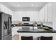 Modern kitchen features sleek white cabinets, stainless steel appliances, and a dark countertop at 1122 Sandstone Run, Sanford, FL 32771