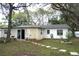 Backyard with a stone walkway, lawn, and the home's exterior in the background at 1211 Phillip St, Winter Springs, FL 32708