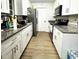 Galley kitchen features granite counters, wood floor, and white cabinets at 1211 Phillip St, Winter Springs, FL 32708