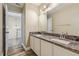 Bathroom featuring a double vanity with granite countertop, framed mirror, and wood-look flooring at 12643 Lakebrook Dr, Orlando, FL 32828
