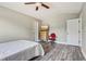 Bedroom featuring gray vinyl floors, neutral walls, a ceiling fan, and two white doors at 12643 Lakebrook Dr, Orlando, FL 32828
