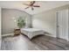 Cozy bedroom with neutral walls, fan, wood-look flooring, and an outdoor view at 12643 Lakebrook Dr, Orlando, FL 32828