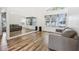 Spacious living room with wood-look floors, large windows, and a full wall mirror at 12643 Lakebrook Dr, Orlando, FL 32828
