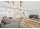 Spacious living room with wood-look floors, staircase, large windows, and a full wall mirror at 12643 Lakebrook Dr, Orlando, FL 32828