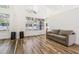Spacious living room with wood-look floors, large windows, and a full wall mirror at 12643 Lakebrook Dr, Orlando, FL 32828