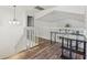 Bright open loft area with wood floors, white railing and view of exterior greenery at 12643 Lakebrook Dr, Orlando, FL 32828