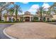 Condominium clubhouse exterior showcasing circular drive, yellow walls, tile roof, and mature landscaping at 1275 Lake Shadow Cir # 13106, Maitland, FL 32751