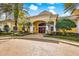 Clubhouse exterior featuring red doors, yellow walls, columns, and lush landscaping at 1275 Lake Shadow Cir # 13106, Maitland, FL 32751