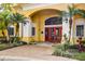 Inviting clubhouse entrance with red double doors, elegant columns, and beautiful landscaping at 1275 Lake Shadow Cir # 13106, Maitland, FL 32751