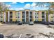 Exterior shot of a yellow apartment building featuring balconies, a parking lot, and blue skies at 1275 Lake Shadow Cir # 13106, Maitland, FL 32751