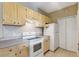 Kitchen with white appliances, light wood cabinets, and tile flooring at 1275 Lake Shadow Cir # 13106, Maitland, FL 32751