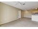 Neutral living room featuring a ceiling fan, carpet flooring, and a view of the small kitchen at 1275 Lake Shadow Cir # 13106, Maitland, FL 32751