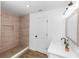 Bright bathroom featuring a tile shower with built-in niche, white vanity, and wood-look tile flooring at 1299 Buccaneer Ave, Deltona, FL 32725