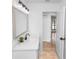 Bathroom with view to hall, featuring a mirror, modern fixtures, and white walls at 1299 Buccaneer Ave, Deltona, FL 32725