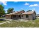 Back exterior view of home with screened-in back porch, lawn, and mature trees at 1299 Buccaneer Ave, Deltona, FL 32725