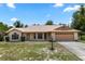 Charming single-story home with brick facade, attached two-car garage, and landscaped front yard on a sunny day at 1299 Buccaneer Ave, Deltona, FL 32725