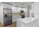 Bright kitchen features stainless steel refrigerator, white countertops, and sleek modern cabinetry at 1299 Buccaneer Ave, Deltona, FL 32725