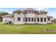 Back of house with rounded bump-outs and multiple windows; large grassy backyard at 13023 Sweet Hill Rd, Polk City, FL 33868