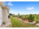 Side yard with rock-lined flower bed and manicured shrubs, and a grassy area running along a fence line at 13023 Sweet Hill Rd, Polk City, FL 33868