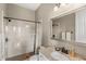 Neutral toned bathroom features a tile shower, granite topped vanity, and decorative mirror at 13023 Sweet Hill Rd, Polk City, FL 33868