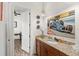 Bathroom boasts a vanity with granite top, wall art, and open doorway at 13023 Sweet Hill Rd, Polk City, FL 33868