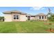 Low-angle view of house featuring a well-kept lawn and stone accents at 13023 Sweet Hill Rd, Polk City, FL 33868