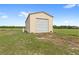 Metal storage shed in a large open field with grassland and a tree line along the back of the property at 13023 Sweet Hill Rd, Polk City, FL 33868