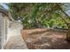 Large backyard with ample space, shaded by mature trees and a concrete patio on the side of the house at 1320 E Lombardy Dr, Deltona, FL 32725
