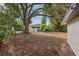 A spacious backyard featuring mature trees and partial fencing, creating a private outdoor retreat at 1320 E Lombardy Dr, Deltona, FL 32725