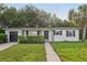 Delightful home featuring black accents, an attached garage, and a well-maintained lawn, providing classic charm at 1320 E Lombardy Dr, Deltona, FL 32725