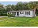 Lovely home showing black accents, an attached garage, and a lush green lawn, creating a welcoming ambiance at 1320 E Lombardy Dr, Deltona, FL 32725