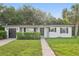 Charming single-story home featuring a well-maintained lawn, dark shutters, and an attached garage at 1320 E Lombardy Dr, Deltona, FL 32725