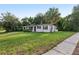 Charming home featuring a well-manicured lawn and a mature palm tree in a serene neighborhood setting at 1320 E Lombardy Dr, Deltona, FL 32725