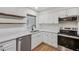 Kitchen area featuring stainless steel appliances, floating shelves, and light countertops at 1320 E Lombardy Dr, Deltona, FL 32725