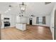 Open-concept living room featuring a kitchen island, modern lighting, and wood-look floors at 1320 E Lombardy Dr, Deltona, FL 32725