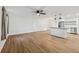 Open concept living space showing durable wood-look floors, a ceiling fan, and seamless flow to the kitchen at 1320 E Lombardy Dr, Deltona, FL 32725