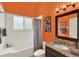 Bathroom with shower/tub combination, vanity, and bright orange walls at 1453 Maple Leaf Ln, Deland, FL 32724