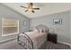 Bedroom features a cozy bed, fan, and large window at 1453 Maple Leaf Ln, Deland, FL 32724