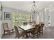 Well-lit dining room with a square table, seating for six and a window with a view of the outdoors at 1453 Maple Leaf Ln, Deland, FL 32724