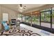 Bright Florida room with ceiling fan, grill, and views of the lush, landscaped backyard at 1453 Maple Leaf Ln, Deland, FL 32724
