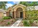 Inviting front entrance with brick archway and complemented by lush landscaping for an appealing facade at 1453 Maple Leaf Ln, Deland, FL 32724