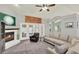 Cozy living room with a fireplace, ceiling fan, plush carpet and ample seating, ideal for relaxation at 1453 Maple Leaf Ln, Deland, FL 32724