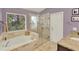 Main bathroom with soaking tub, glass-enclosed shower and granite topped vanity at 1453 Maple Leaf Ln, Deland, FL 32724