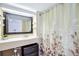 Well-lit bathroom featuring a large mirror, fresh vanity, and shower/tub combo with decorative curtain at 151 E Washington St # 424, Orlando, FL 32801