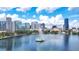 Aerial view of the city skyline reflected in a lake with a water fountain in the middle, under a blue sky at 151 E Washington St # 424, Orlando, FL 32801