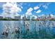 Beautiful lakeside view with modern architecture and sculptures reflecting clear blue sky with scattered clouds at 151 E Washington St # 424, Orlando, FL 32801