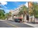 Orlando Public Library view with architecture details, palm trees, and street perspective with parked cars and passersby at 151 E Washington St # 424, Orlando, FL 32801