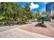 Street view with tree-lined walkway, a bus shelter, and historical sign with city buildings in the background at 151 E Washington St # 424, Orlando, FL 32801